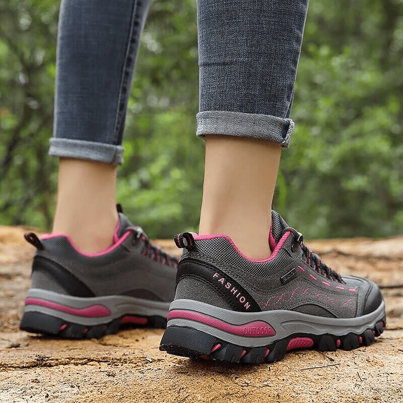 Women's trekking sneakers with lace-up design perfect for hiking, featuring durable rubber sole and comfortable support.